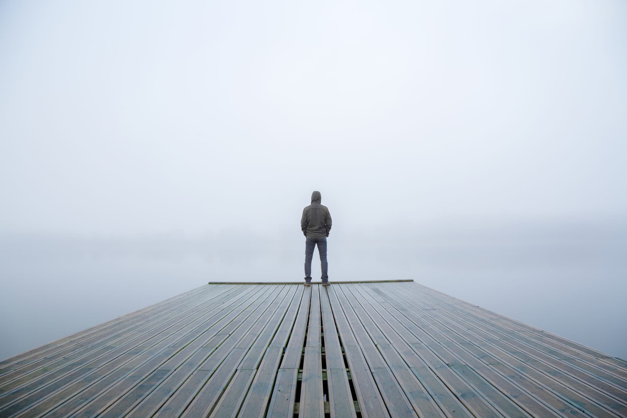 young,man,standing,alone,on,edge,of,footbridge,and,staring