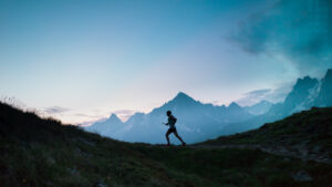a,single,trail,runner,,silhouetted,against,the,sky,at,sunrise