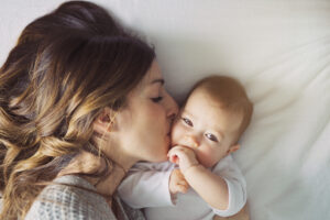 a,mother,and,baby,child,on,a,white,bed.