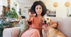 woman,,remote,and,relax,with,dog,for,watching,tv,,change