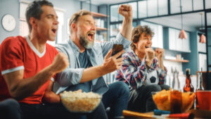 at,home,three,soccer,fans,sitting,on,a,couch,watch