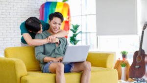 asian,teenager,male,gay,businessman,sitting,on,sofa,holding,laptop